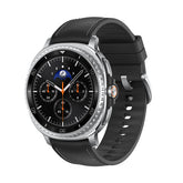 Combo view of the Samsung Galaxy Watch 8 Classic 46mm L500, showcasing the large AMOLED display with a traditional rotating bezel alongside a side profile shot highlighting the sleek physical control buttons. Smartwatch with black strap on a white background
