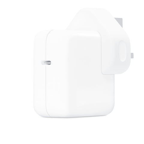 Front combo view of an Apple 30W USB-C power adapter standing upright next to its clean white retail box, showcasing the iconic glossy finish and minimalist packaging graphics.